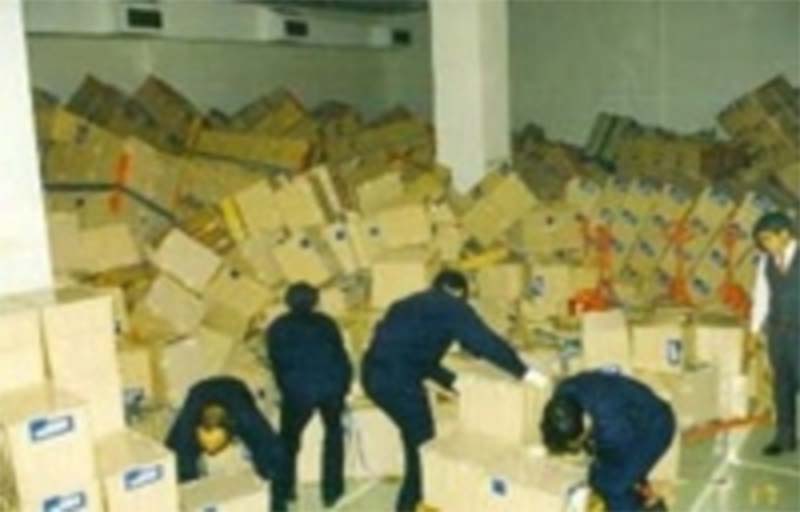 阪神・淡路大震災で崩れた大量の段ボール箱を片づける職員