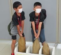 貨幣用大袋の重量体験をしている写真
