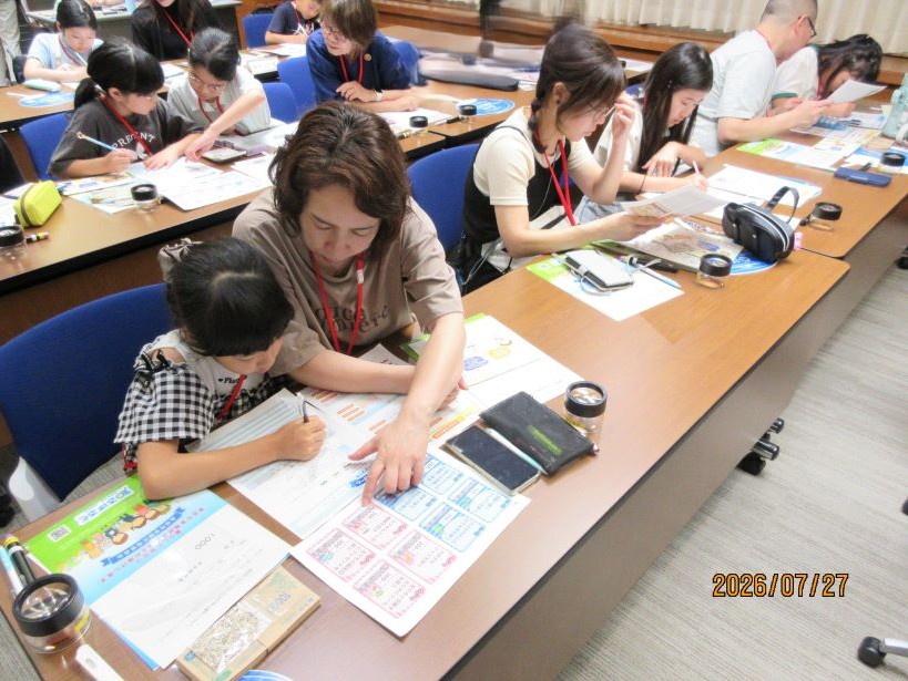 参加者がおこづかいゲームのワークシートに記入している様子