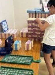 参加者が模擬紙幣１億円のパックを触る様子