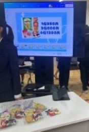 ラッピングされた菓子商品と生徒が作った広告画面