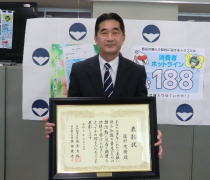 藤野氏が表彰状を持つ写真