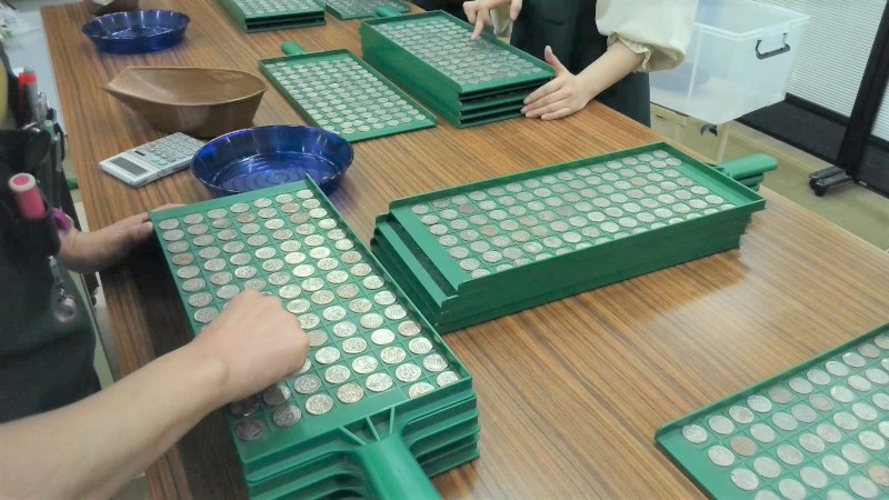 汚れた硬貨が本物かどうかを調べている様子