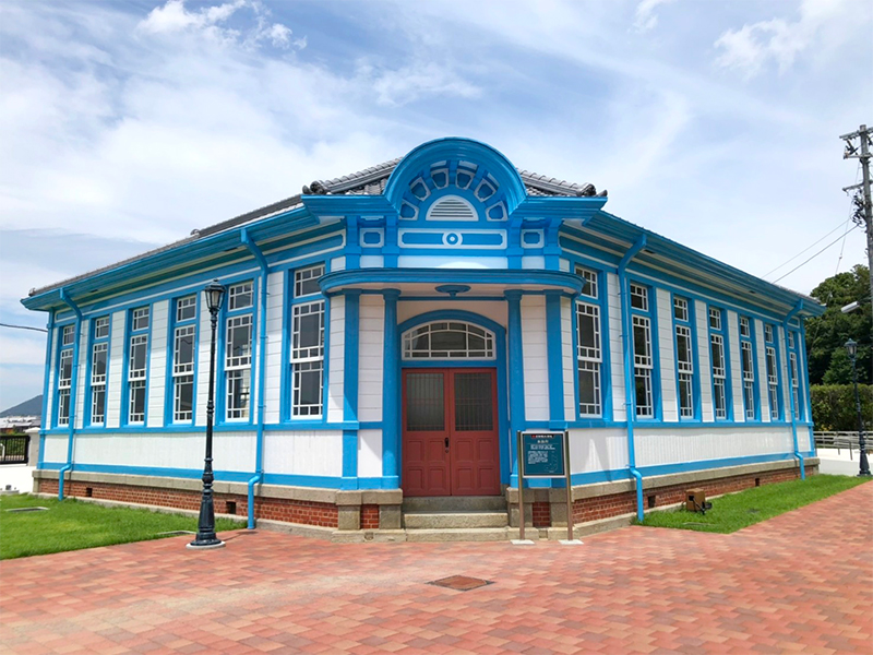 大正時代に当時の建築様式で建設された、青と白のコントラストが美しい浄水場の事務所の写真です。